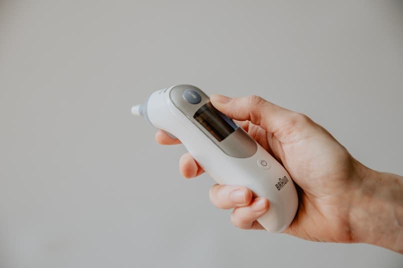Hand holding thermometer for temperature check